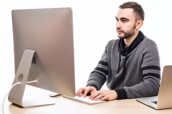 Man handling accounts on his PC by using field service management software